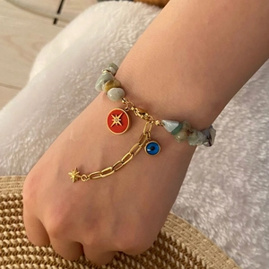 Beaded natural stone bracelet with evil eye and star charms on a model wrist
