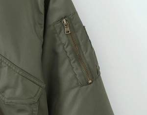 Detail of army green bomber jacket sleeve featuring a utility zipper pocket and stitching