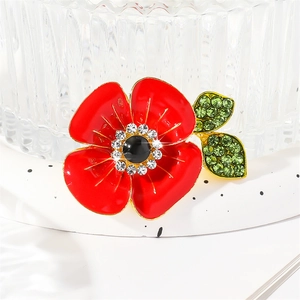Vibrant red enamel poppy flower brooch with gold plating and sparkling green leaf crystals