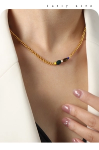 Detail of gold plated stainless steel necklace with colorful beads on a model