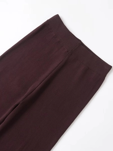 Dettaglio della trama a coste e fascia elastica in vita sui pantaloni bordeaux