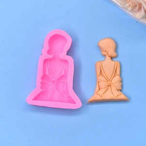 Detail of a 3D girl with big bow silicone mold and finished resin craft on blue background