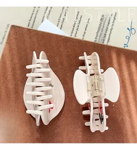 Close-up of cream hair claws with floral patterns showing internal structure and grip detail