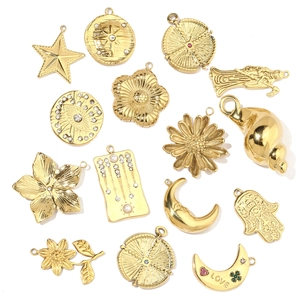 Flat lay of gold plated star and moon stainless steel charms with pearl accents