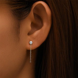 Détail de boucle d'oreille en argent S925 avec diamant rond et fine chaîne pendante