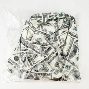 Detail view of slouchy beanie with $100 dollar bill print in transparent packaging
