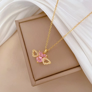 Luxurious gold winged necklace with a heart-shaped pink crystal and sparkling zircons