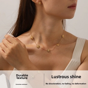 Close-up of a gold-plated stainless steel sunflower jewelry set worn by a model