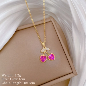 Macro detail of gold cherry necklace with pink crystal heart and product dimensions