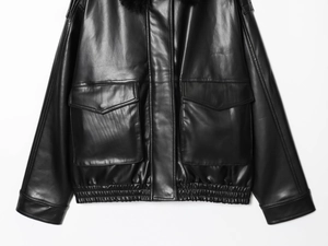 Détail d'une veste en simili cuir noir avec col en fourrure amovible et poches à rabat