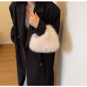 Detail of soft plush beige crossbody bag paired with a black wool coat for autumn