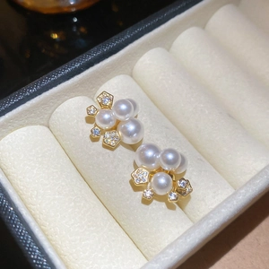 Gros plan de boucles d'oreilles dorées avec perles blanches et accents en zircone