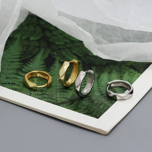 Detail of s925 silver geometric hoop earrings in gold and silver finish on leaf card