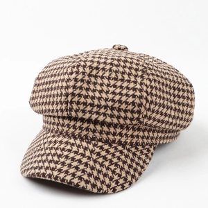 Detailed texture of brown houndstooth newsboy cap with classic woolen fabric finish
