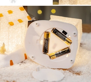 Detail showing the bottom battery compartment of the Christmas light-up snow house ornament