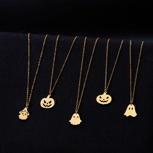 Detail of five gold stainless steel necklaces with ghost and pumpkin charms for Halloween
