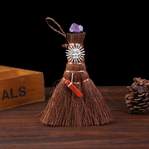 Detail of Wicca mini broom with purple crystal and sun charm for altar decor