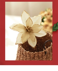 Detailed view of cream artificial Christmas flower with gold glitter edges in woven basket