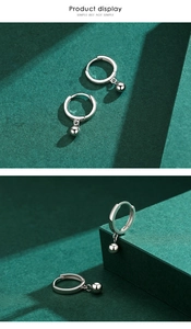 Detail view of s925 sterling silver hoop earrings with polished bead pendants on green blocks