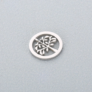 Macro detail of silver stainless steel round hollow tree of life pendant with intricate design