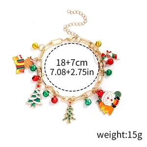 Detailed view of Christmas bracelet charms including Santa, tree and bells on gold chain