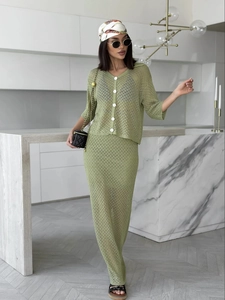 Detail of green hollow-out knit two-piece set showing button-up cardigan and maxi skirt