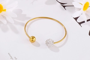 Vue détaillée du bracelet jonc doré avec boules de cristal pavées et perles d'acier