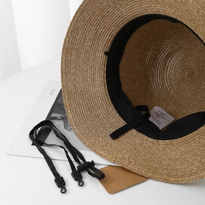 Detailed interior of straw hat with adjustable strap and woven texture detail