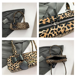 Detail view of leopard print shoulder bag with dual zippers and heart bow charm