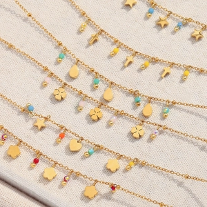 Close-up of gold stainless steel chains with colorful beads and varied pendants