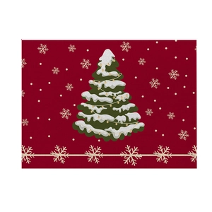Close-up of red Christmas placemat with linen texture featuring printed trees and snowflakes