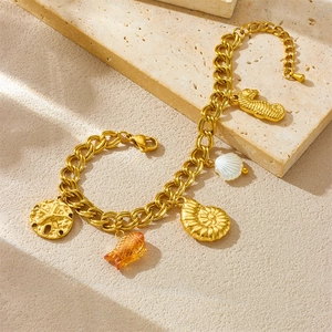 Bracelet marin doré avec pendentifs hippocampe, étoile de mer et coquillage sur pierre