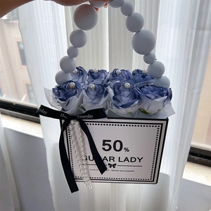 Detail of luxury rose gift box with blue artificial flowers and pearl handle decoration