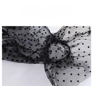 Detailed view of elegant black polka dot lace mesh fabric with intricate French netting