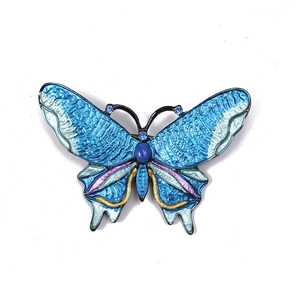 Elegant butterfly brooch with blue enamel wings and sparkling crystal accents on white background