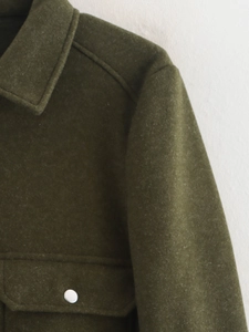 Detalle de la chaqueta verde oliva con cuello de punta y tejido texturizado tipo lana