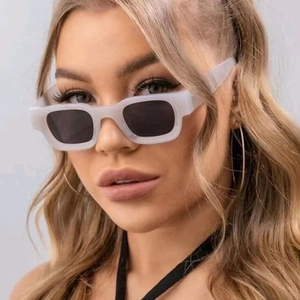 Close-up of matte white square frame sunglasses with black polarized lenses on a model