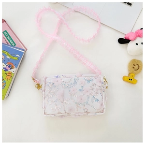 Detail of floral girl's crossbody bag with pink organza flowers and lace shoulder strap