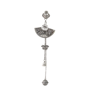Detailed close-up of a vintage silver fan charm with tassels and intricate hollow metalwork