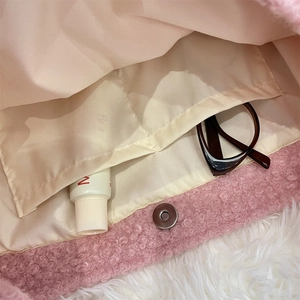 Detail of pink teddy fleece tote bag showing cream lining and magnetic clasp
