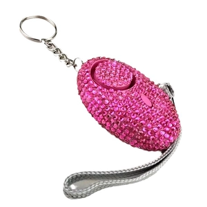 Pink rhinestone personal safety alarm keychain for women on a white background