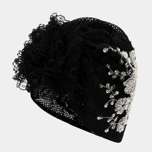 Close-up of black lace turban featuring ruffled flower lace and silver sequin embroidery