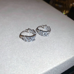 Macro shot of silver U-shaped wheat ear earrings with marquise-cut cubic zirconia