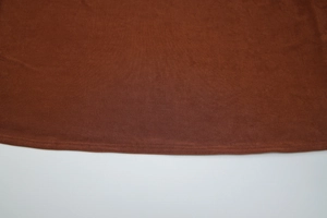 Close-up of double-needle stitching and high-density knit hem on dark brown dress