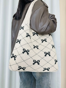 Close-up detail of cream knit shoulder bag with black bow and argyle pattern