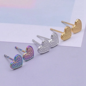 Detailed view of heart-shaped stainless steel earrings in gold, silver, and rainbow colors