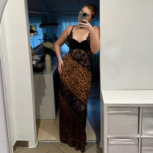 Détail d'une robe longue pour femme avec haut en dentelle noire et jupe imprimé léopard