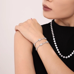 Silver stackable tennis necklace and rectangle zircon bracelets set on black knit fabric