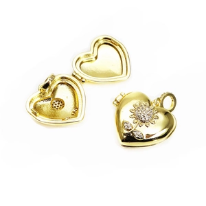 Detail of gold heart locket pendant with sunflower engraving and cubic zirconia stones
