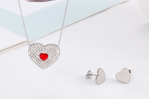 Detail showing silver heart jewelry set with red gemstone and sparkling diamond accents
